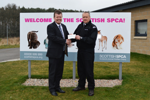 Haydn Davies hands over cheque to Graeme Innes at the SSPCA re-homing centre in Drumoak.